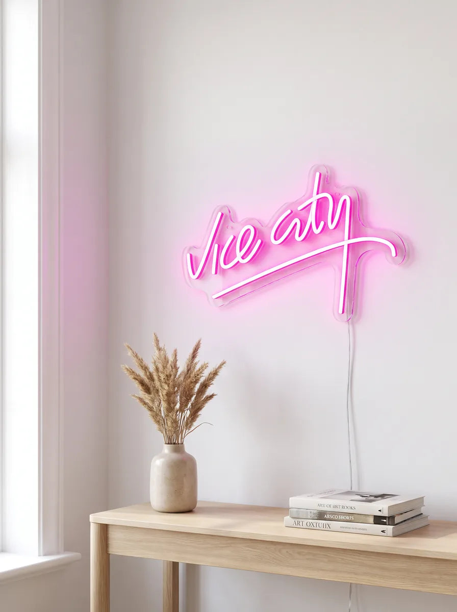 Vice City Neon an einer hellen Wand über einer Konsole mit Trockengräsern